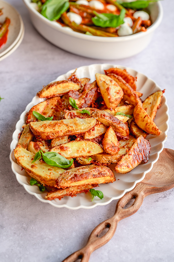 Knapperige parmezaanaardappeltjes met sperziebonen in tomatensaus